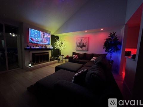 A modern living room with a large couch and a television on the wall.
