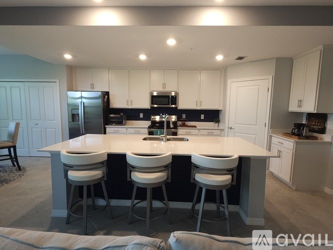 A kitchen with a large island and bar stools.
