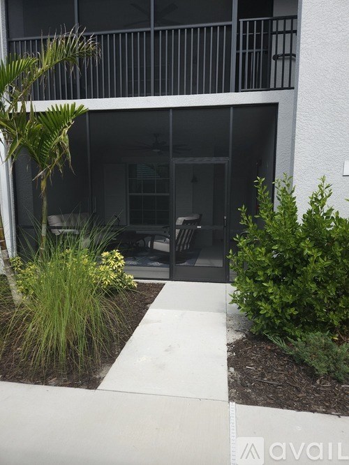 A white building with a balcony and a white walkway leading to it.