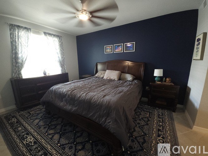 A bedroom with a bed, nightstand, and window.