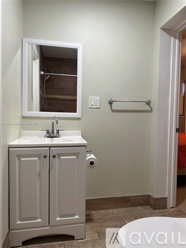 A white bathroom with a sink and mirror.