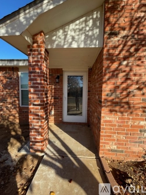 A house with a white door and a brick pillar.