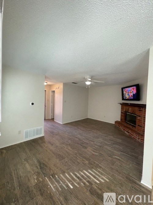 A living room with a fireplace and a flat screen TV mounted on the wall.
