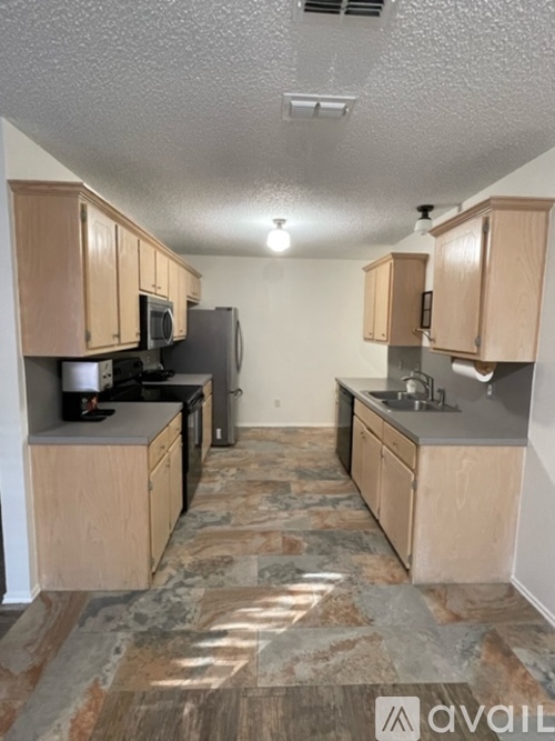 A kitchen with wooden cabinets and a granite countertop.