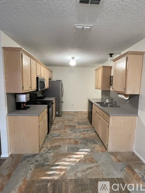 A kitchen with wooden cabinets and a granite countertop.