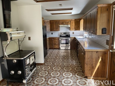 A kitchen with a black stove top oven and a white refrigerator.