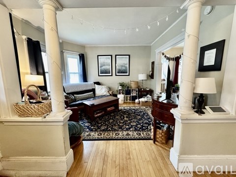 A living room with a large rug and a wooden floor.