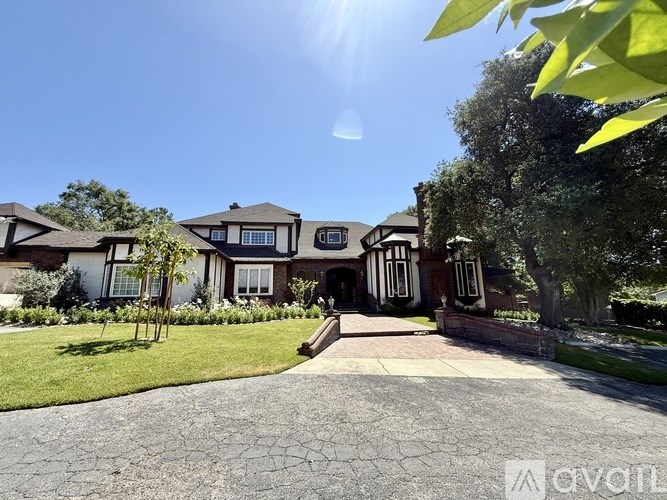 A house with a driveway and a sunny sky above.