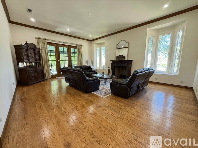 A spacious living room with hardwood floors and a large window.