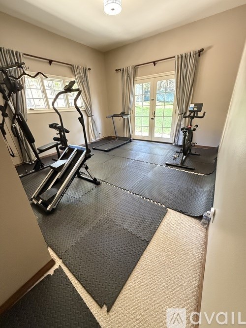 A well-equipped home gym with a treadmill, exercise bike, and other workout machines.