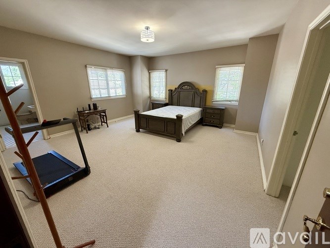 A bedroom with a bed, dresser, and window.