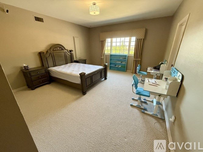 A bedroom with a bed, chair, and desk.
