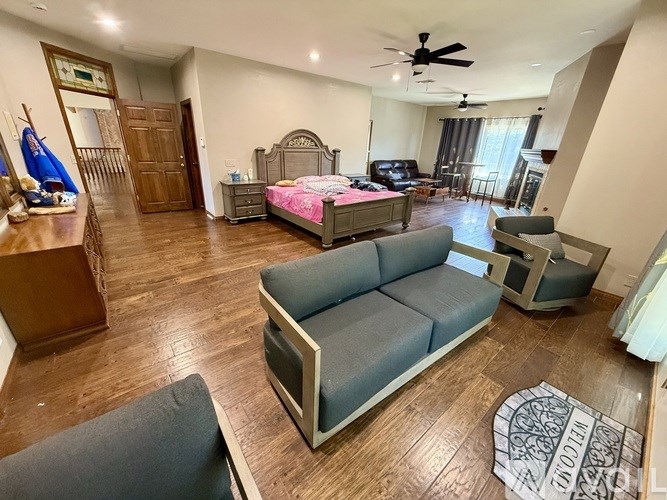 A bedroom with a bed, a couch, and a ceiling fan.