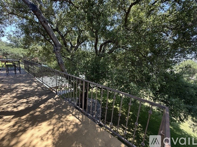 A metal fence runs along a concrete walkway.