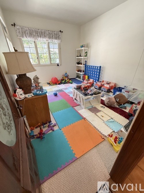 A tennis court is surrounded by a fence and trees.