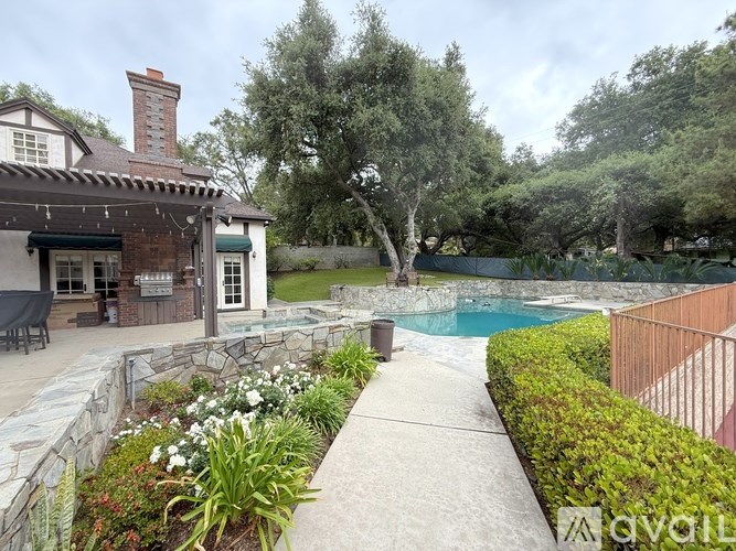 A backyard with a pool and a house.