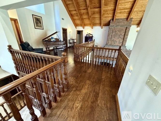 A wooden staircase with a railing leads to a second floor.