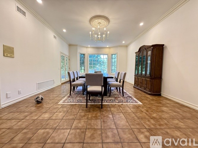 A spacious dining room with a large table and chairs.