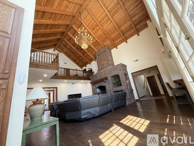 A living room with a grey couch and a wooden ceiling.