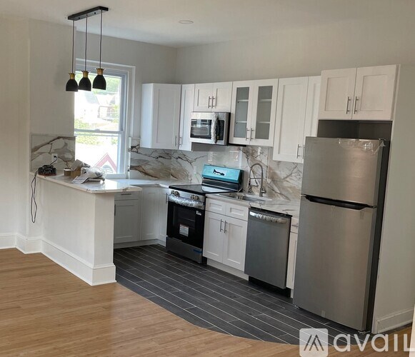 A kitchen with white cabinets and a wooden floor.