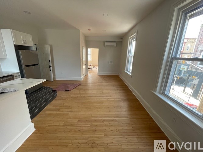 A long hallway with wood floors and white walls.