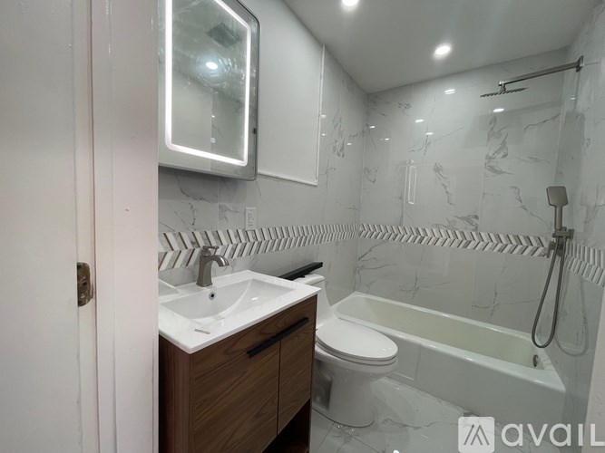 A bathroom with a sink, toilet, and bathtub.