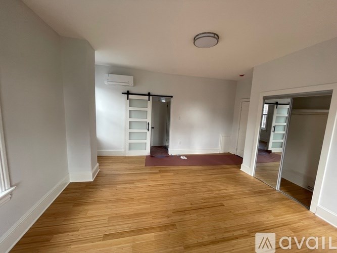 A room with wooden flooring and a ladder in the corner.
