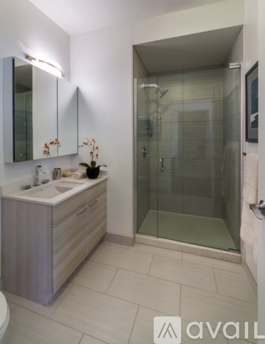 A bathroom with a sink, mirror, and glass shower door.