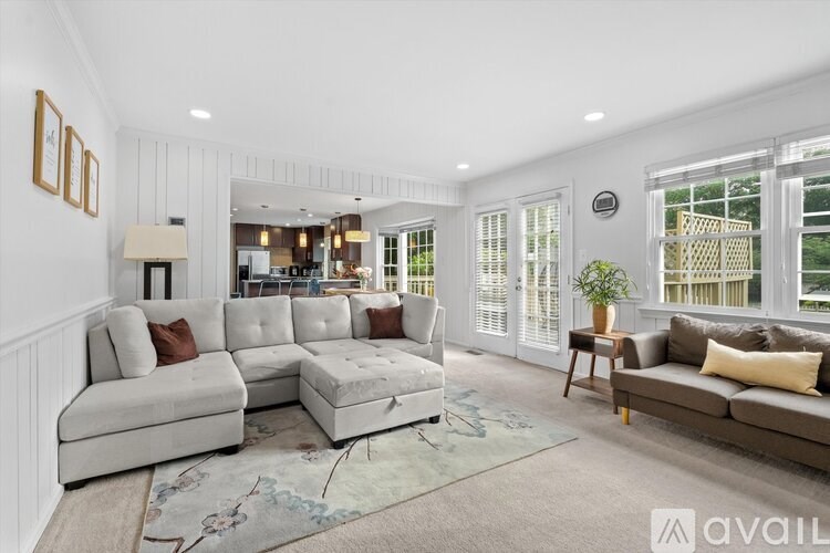 A living room with a white couch and a rug.