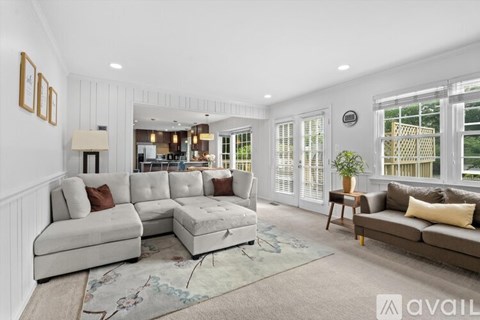 A living room with a white couch and a rug.