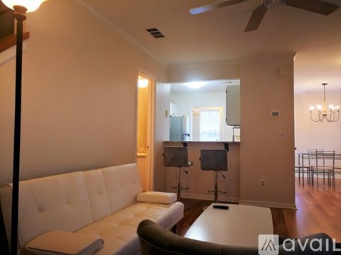 A living room with a white couch and a television.