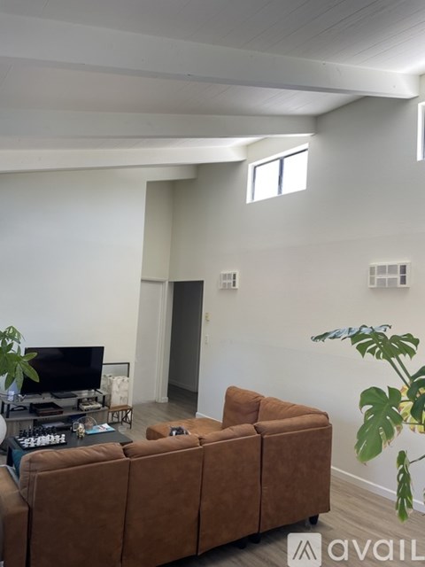 A living room with a brown couch and a television.