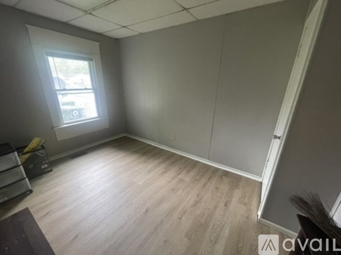 A room with a window and a wooden floor.