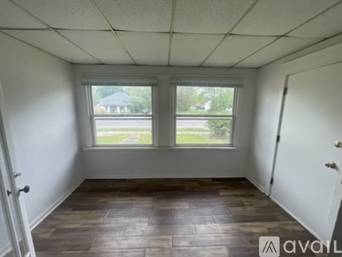A room with a window and wooden flooring.