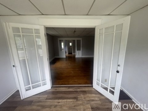 A hallway with white doors and wooden floors.