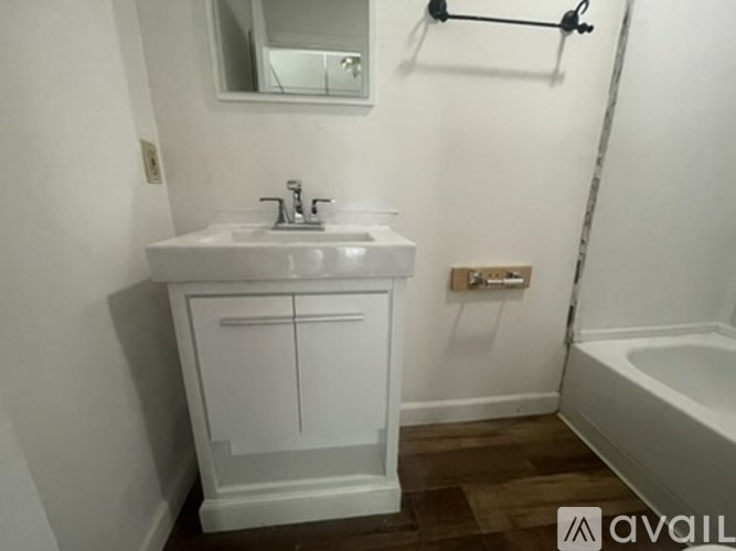 A white sink with a cabinet below it and a mirror above.