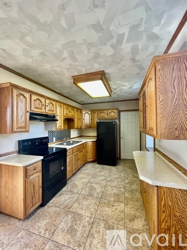 A kitchen with wooden cabinets and black appliances.