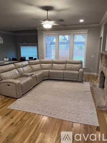 A living room with a large sectional sofa and a rug.