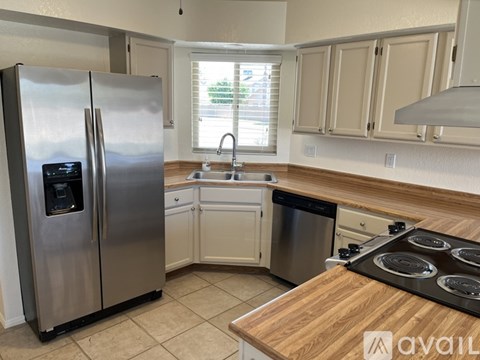 A kitchen with a stainless steel refrigerator and wooden countertops.