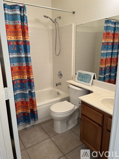 A bathroom with a toilet, sink, and shower curtain.