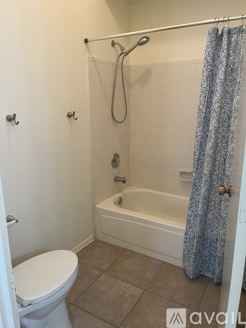 A bathroom with a toilet, tub, and shower.