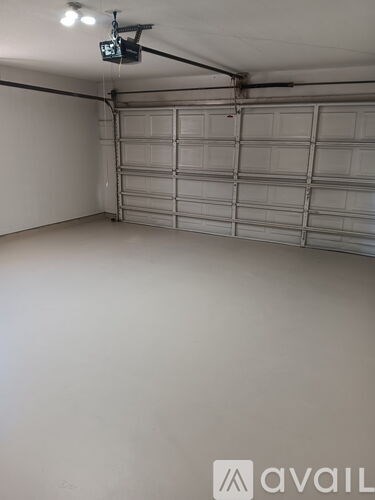 A garage with a closed door and a camera hanging from the ceiling.