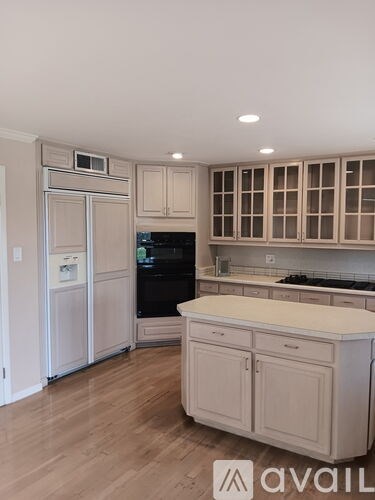 A kitchen with a black stove top oven and a white island.