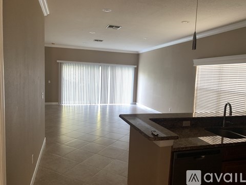 A kitchen with a counter and a window with blinds.