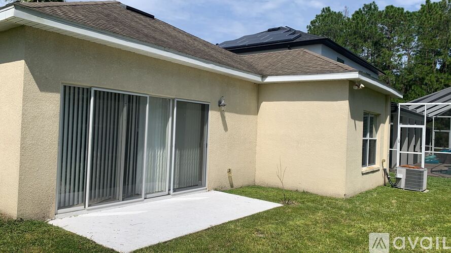 A house with a beige exterior and a black roof.