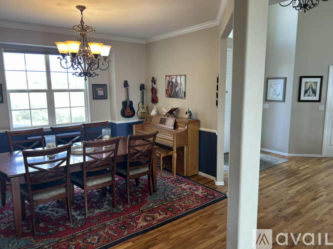 A dining room with a wooden table and chairs.
