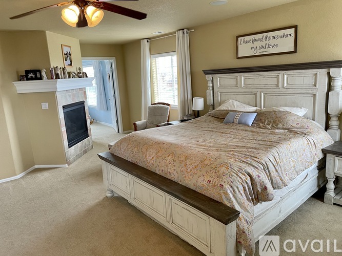 A bedroom with a large bed and a fireplace.
