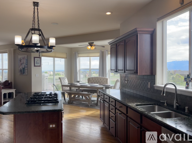 A modern kitchen with dark wood cabinets and a black countertop.