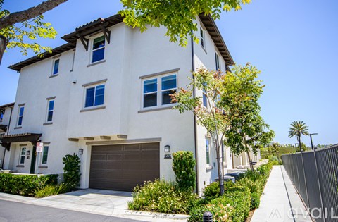 A white two-story house with a brown garage door.