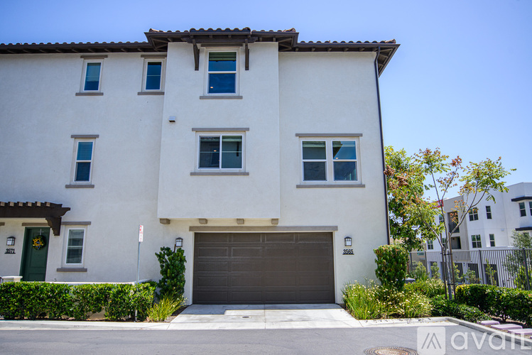 A white two-story house with a brown garage door.